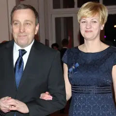 Cezary Grabarczyk z żoną, w eleganckich strojach. Może rozmawiają o swoich dzieciach i ich przyszłości.