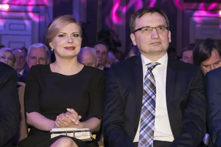 Patrycja Kotecka, żona Zbigniewa Ziobro, w czarnej sukience, siedzi obok męża w garniturze.