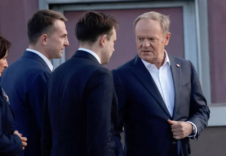 Donald Tusk rozmawia z innymi politykami. To przykład, co to jest koalicja – wspólne działanie dla osiągnięcia celu.
