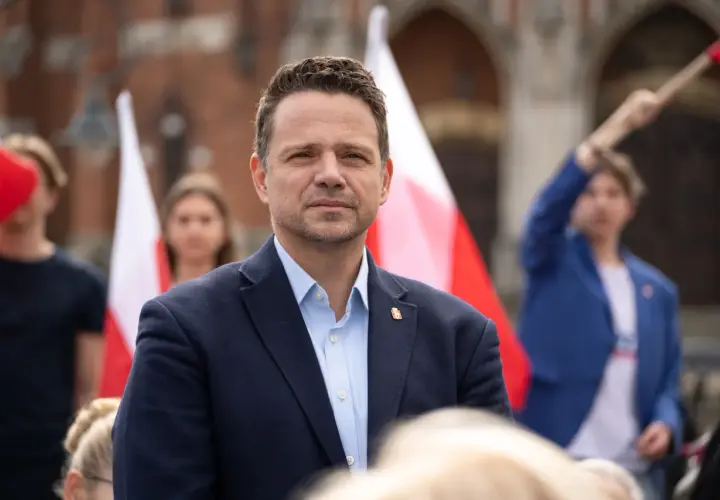 Rafał Trzaskowski na tle flag. Chcesz nawiązać kontakt e-mail?