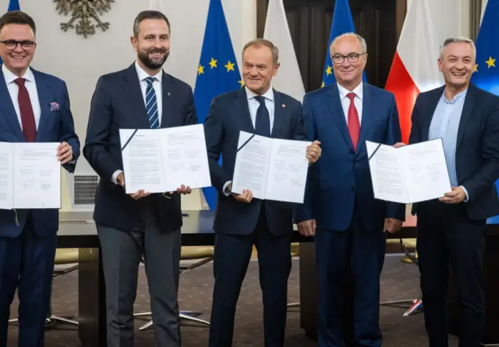 Pięciu polityków prezentuje dokumenty. Ich uśmiechy sugerują sukces, być może związany z tym, ile posłów ma koalicja rządząca.