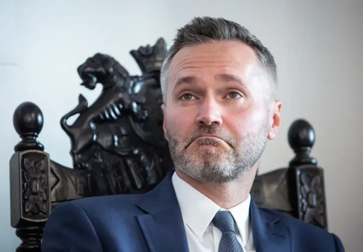 Jarosław Wałęsa, w wieku, w którym doświadczenie miesza się z energią, siedzi na ozdobnym krześle.