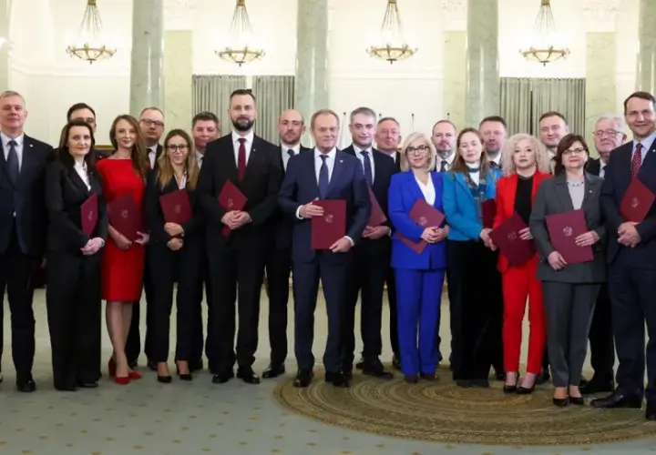 Nowy skład rządu pozuje do zdjęcia z dokumentami.