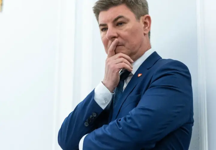 Jan Grabiec w garniturze, zamyślony, z palcem przy ustach. Może myśli o przyszłości dzieci?