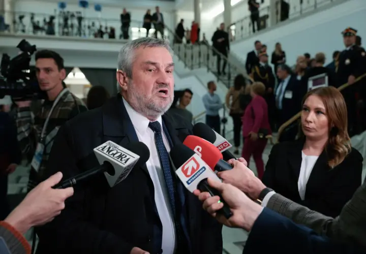 Mężczyzna z siwą brodą, przypominający ojca Agnieszki Pomaskiej, udziela wywiadu dziennikarzom.