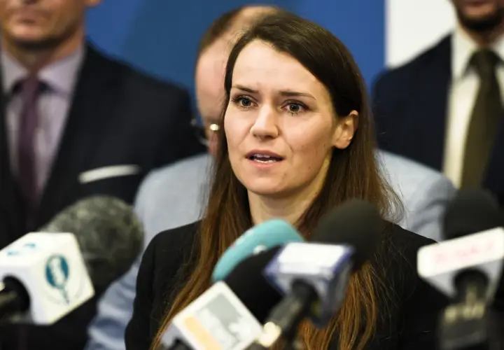Agnieszka Pomaska przemawia do mediów. W tle widać mężczyzn, być może jej rodziców lub współpracowników.
