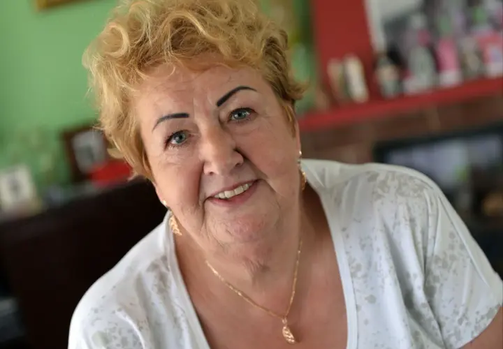 Uśmiechnięta Henryka Krzywoń Strycharska z blond włosami i złotym naszyjnikiem.