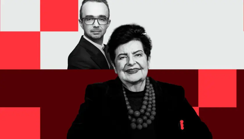 Uśmiechnięta kandydatka po na prezydenta, z mężczyzną w okularach w tle.