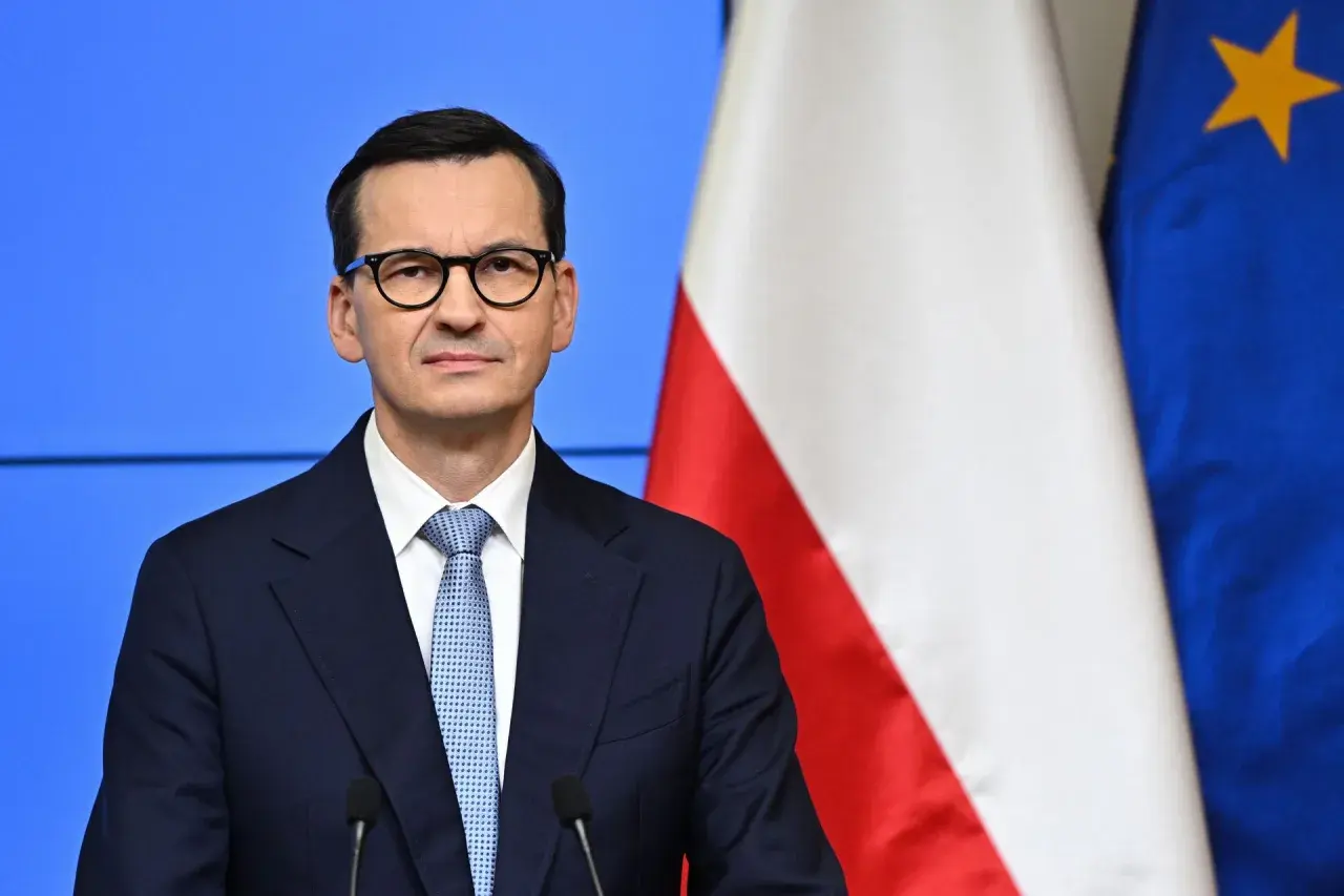 Mateusz Morawiecki w okularach, obok flagi Polski i UE. Jego rządzenie trwa od 2017 roku, kiedy to zastąpił Beatę Szydło.