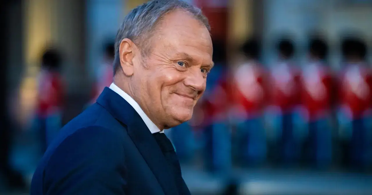 Uśmiechnięty Donald Tusk na tle tłumu podczas konwencji po w Płońsku.