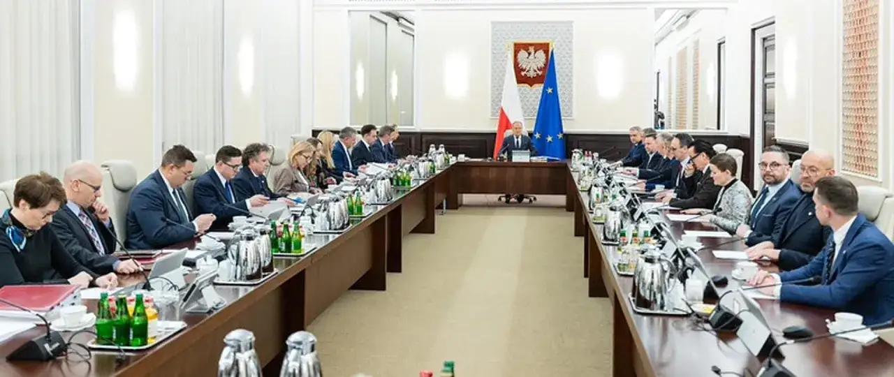 Uczestnicy spotkania przy długim stole, gdzieś w tle widać flagi Polski i UE. Może ktoś szuka numer do Tuska?