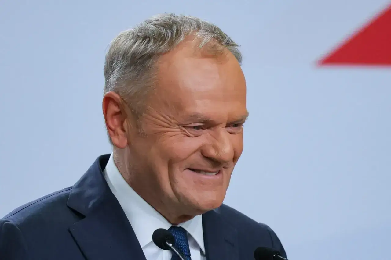 Uśmiechnięty Donald Tusk, symbol poparcia dla jego polityki.